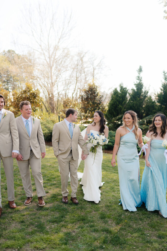 a wedding party walks across the front lawn of the lumpkin house wedding venue in albertville, alabama