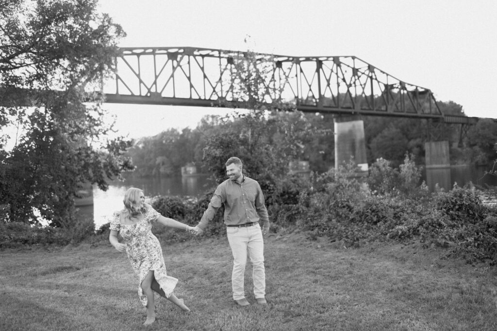 a couple runs through a river walk near the puget sound during their engagement photos with seattle engagement photographer sarah mismash