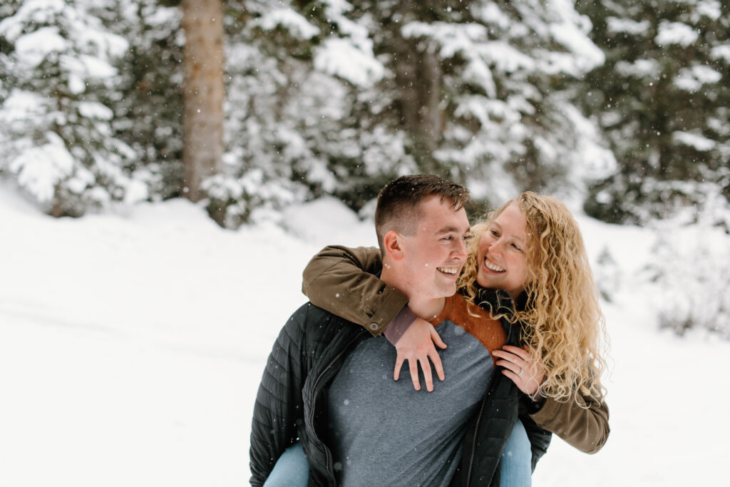 a couple laughs in a snowstorm during their engagement photos with washington engagement photographer sarah mismash