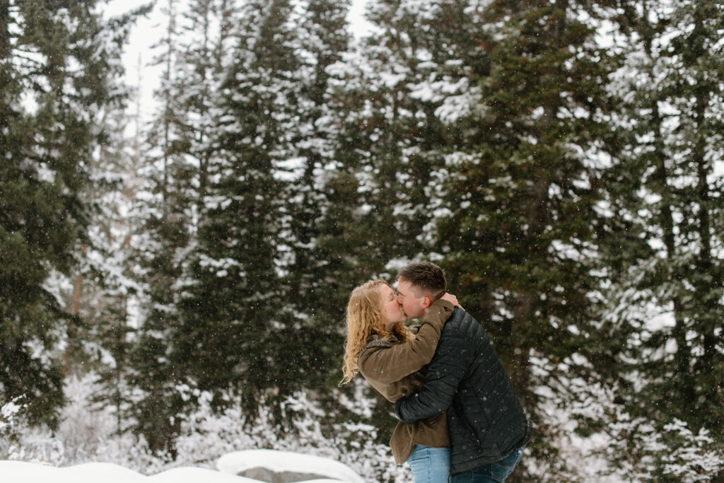 a couple kisses in a snowstorm during their engagement photos with washington engagement photographer sarah mismash