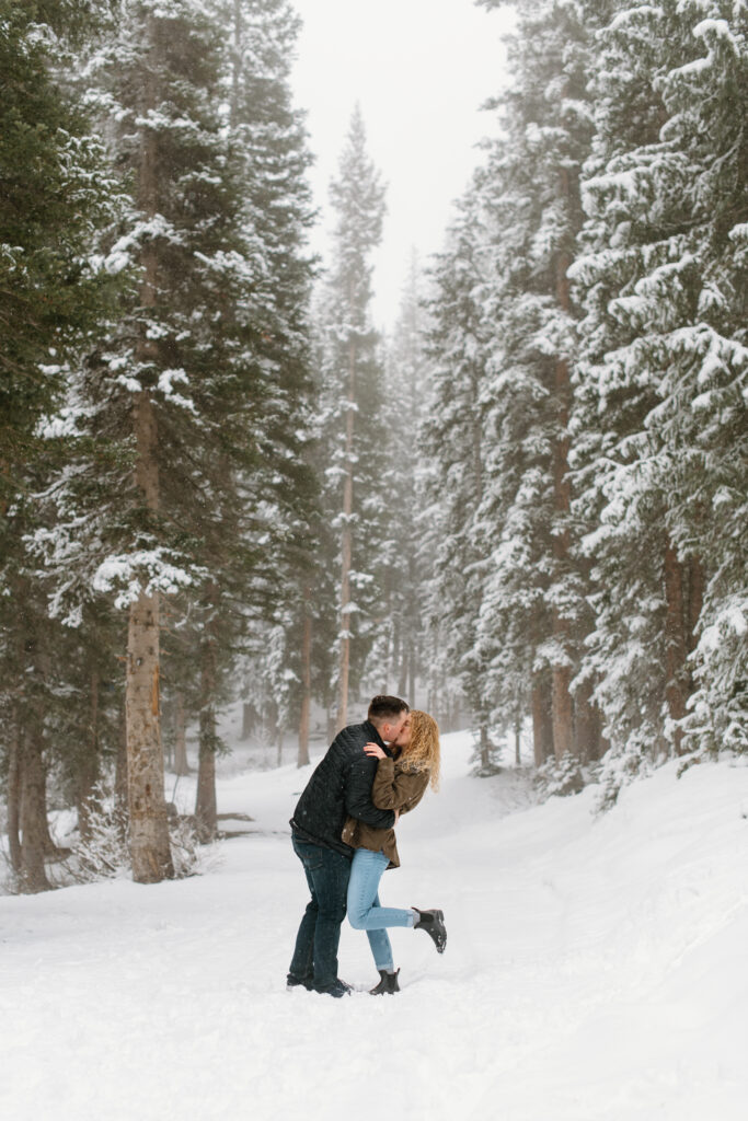 a couple kisses in a snowstorm during their engagement photos with washington engagement photographer sarah mismash