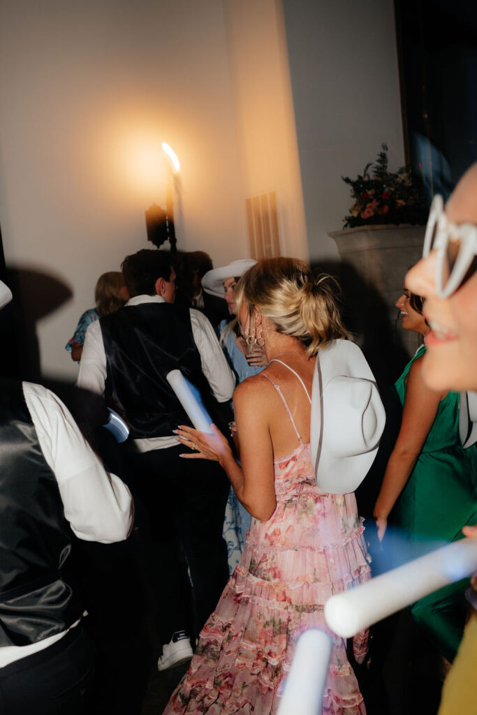 a bridesmaid dons a cowboy hat and dances during a wedding reception in chattanooga, tennessee at howe farms