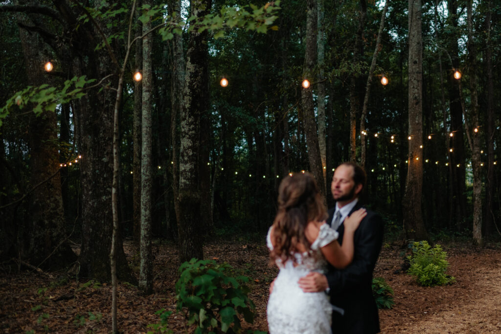 a couple smiles together during their first look at the glasshouse alabama eden with alabama wedding photographer Sarah Mismash