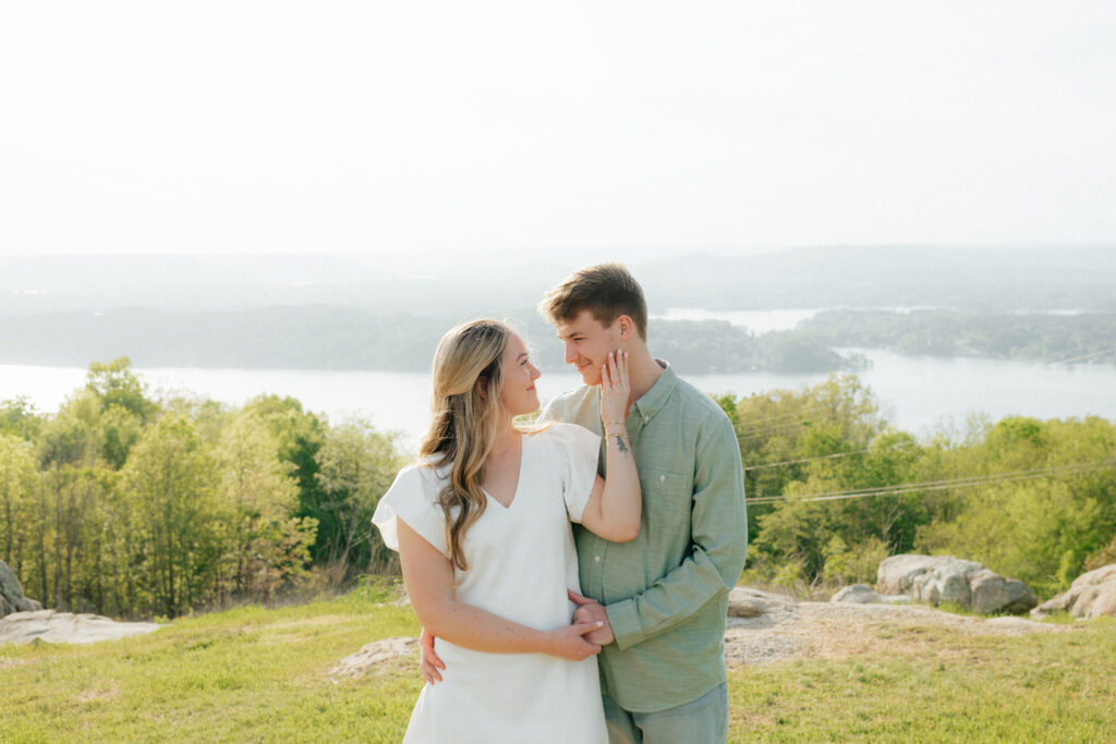 a couple smiles at each other during their engagement photos at weathington park in guntersville, Alabama