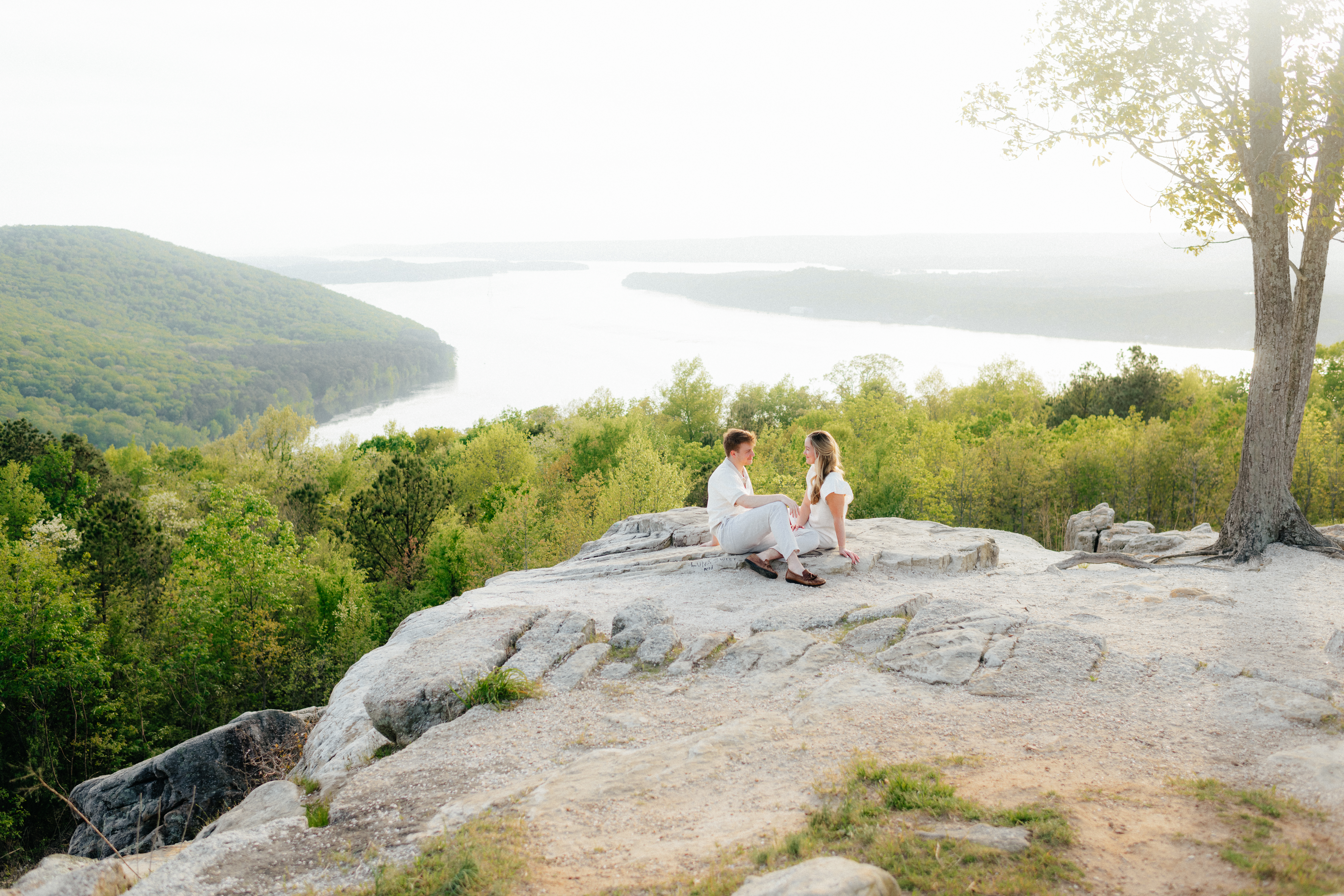 a couple watches the sunset over guntersville lake at weathington park in north Alabama during their engagement photos with guntersville wedding photographer Sarah Mismash