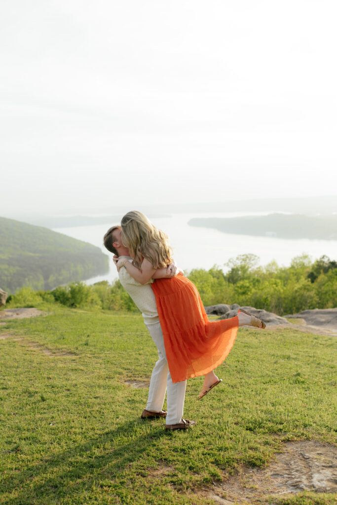a couple kisses at the overlook at weathington park near guntersville lake, Alabama and then spins