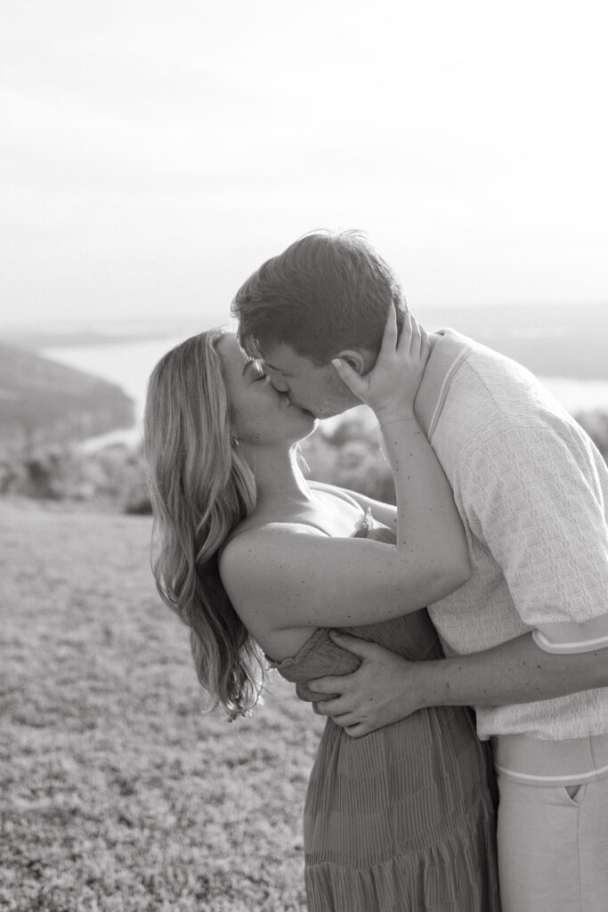 a couple kisses at the overlook at weathington park near guntersville lake, Alabama during their engagement photos