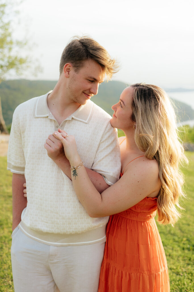 a couple smiles at each other during their engagement photos at weathington park near guntersville, Alabama