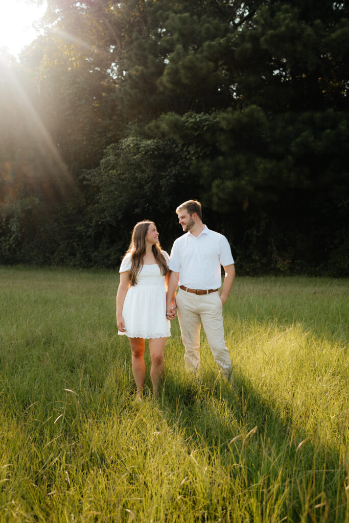 a couple stands together during their field engagement photos in calera, alabama, photography by Birmingham alabama wedding photographer Sarah Mismash