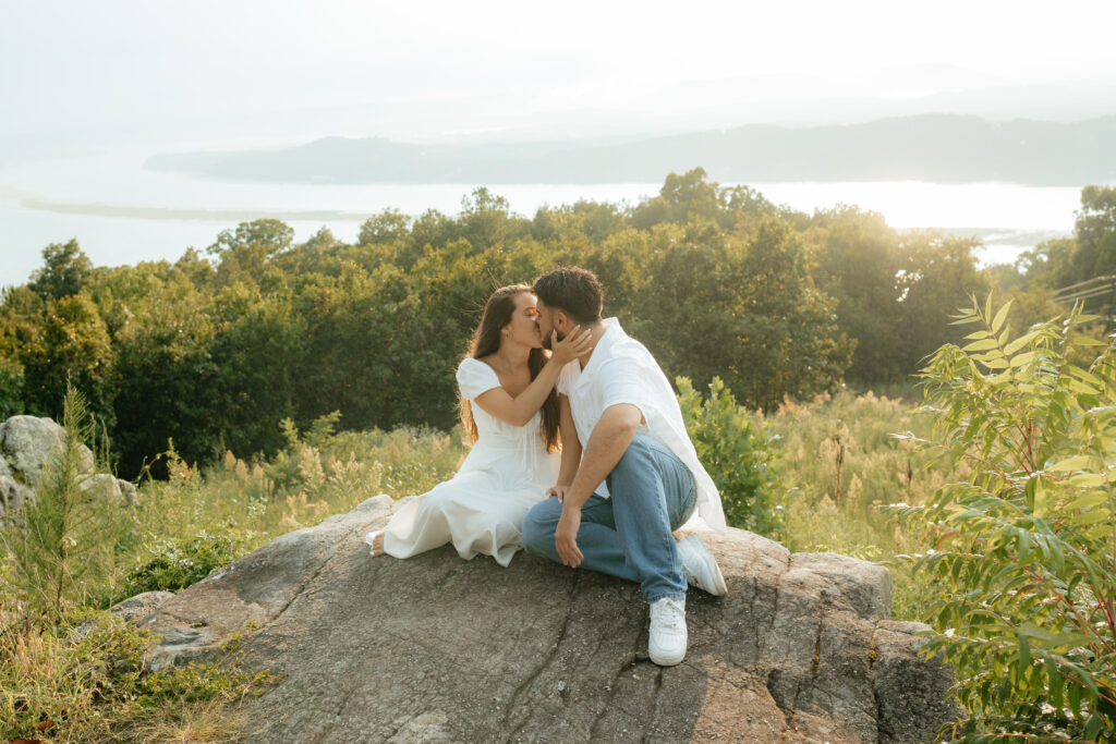 A couple kiss with a panoramic background at their Engagement Photos, Weathington Park, Guntersville, Alabama. Photos produced and edited by Alabama and Washington Wedding Photographer Sarah Mismash
