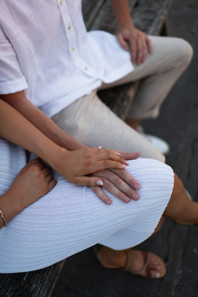 A couple hold hands after a surprise proposal at Fairhope Municipal Pier, Alabama. Photos taken by Sarah Mismash Photography