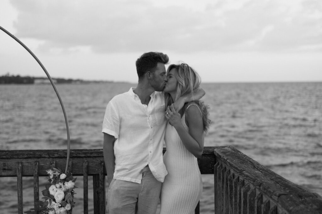 A couple kiss after a surprise proposal at Fairhope Municipal Pier, Alabama. Photos taken by Sarah Mismash Photography