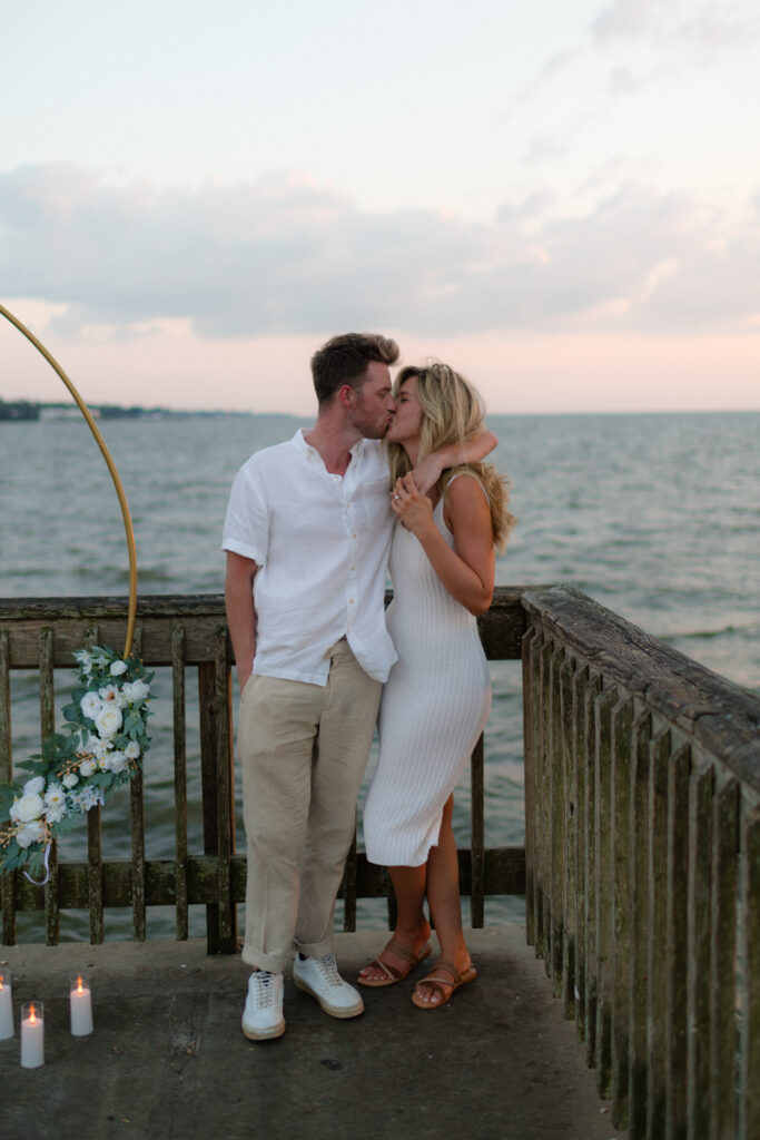 A couple kiss after a surprise proposal at Fairhope Municipal Pier, Alabama. Photos taken by Sarah Mismash Photography