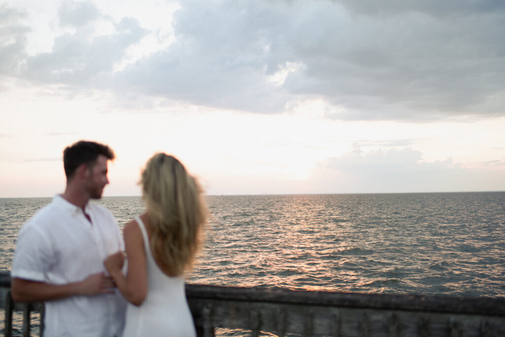 A couple enjoy a panoramic view after a surprise proposal at Fairhope Municipal Pier, Alabama. Photos taken by Sarah Mismash Photography