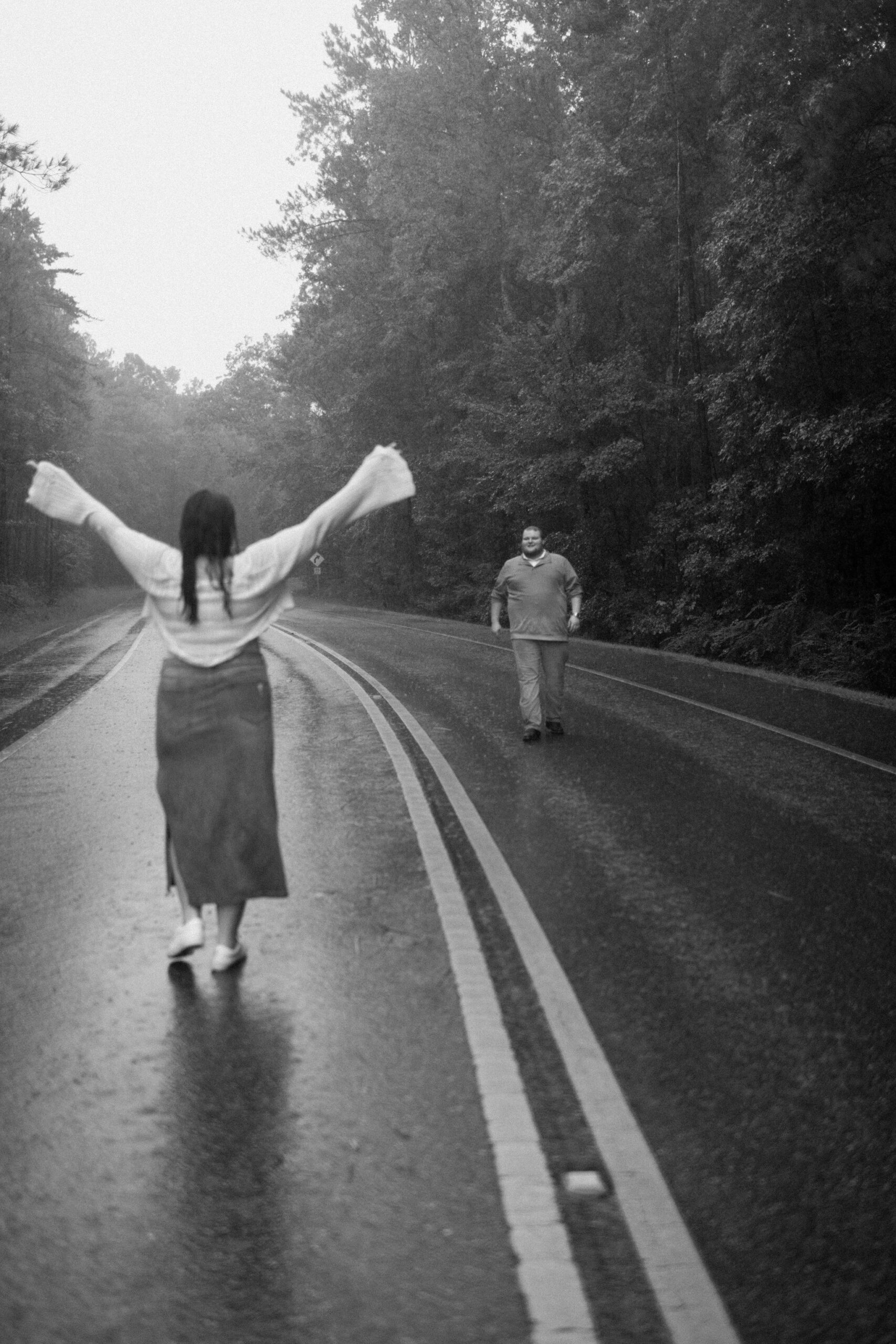 a couple dances in the rain during their urban engagement photos with seattle, washington engagement photographer sarah mismash