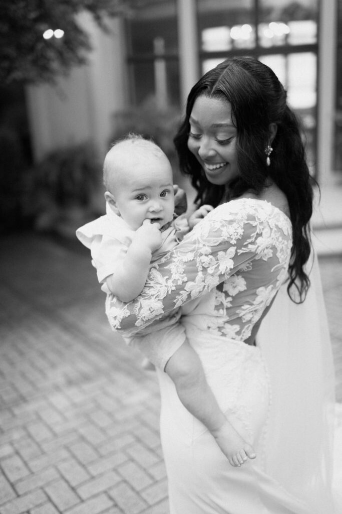 a bride smiles at her young son during family photos after his wedding at lake Martin with alabama wedding photographer Sarah Mismash