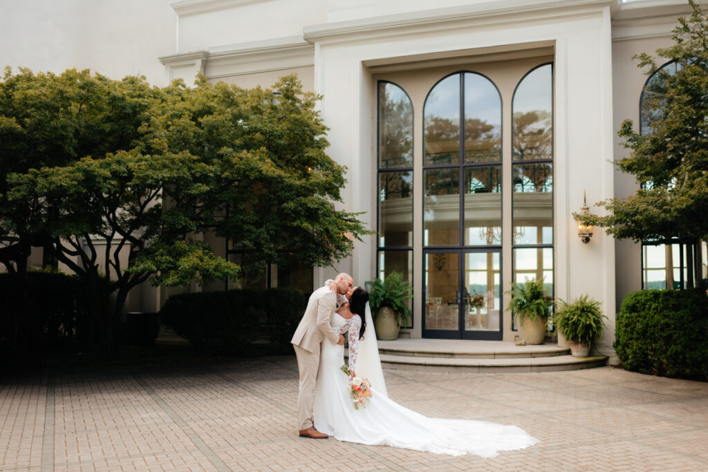 a portrait of a couple kissing after their marriage ceremony taken by alabama wedding photographer Sarah Mismash during a summer wedding at lake Martin near Alexander city