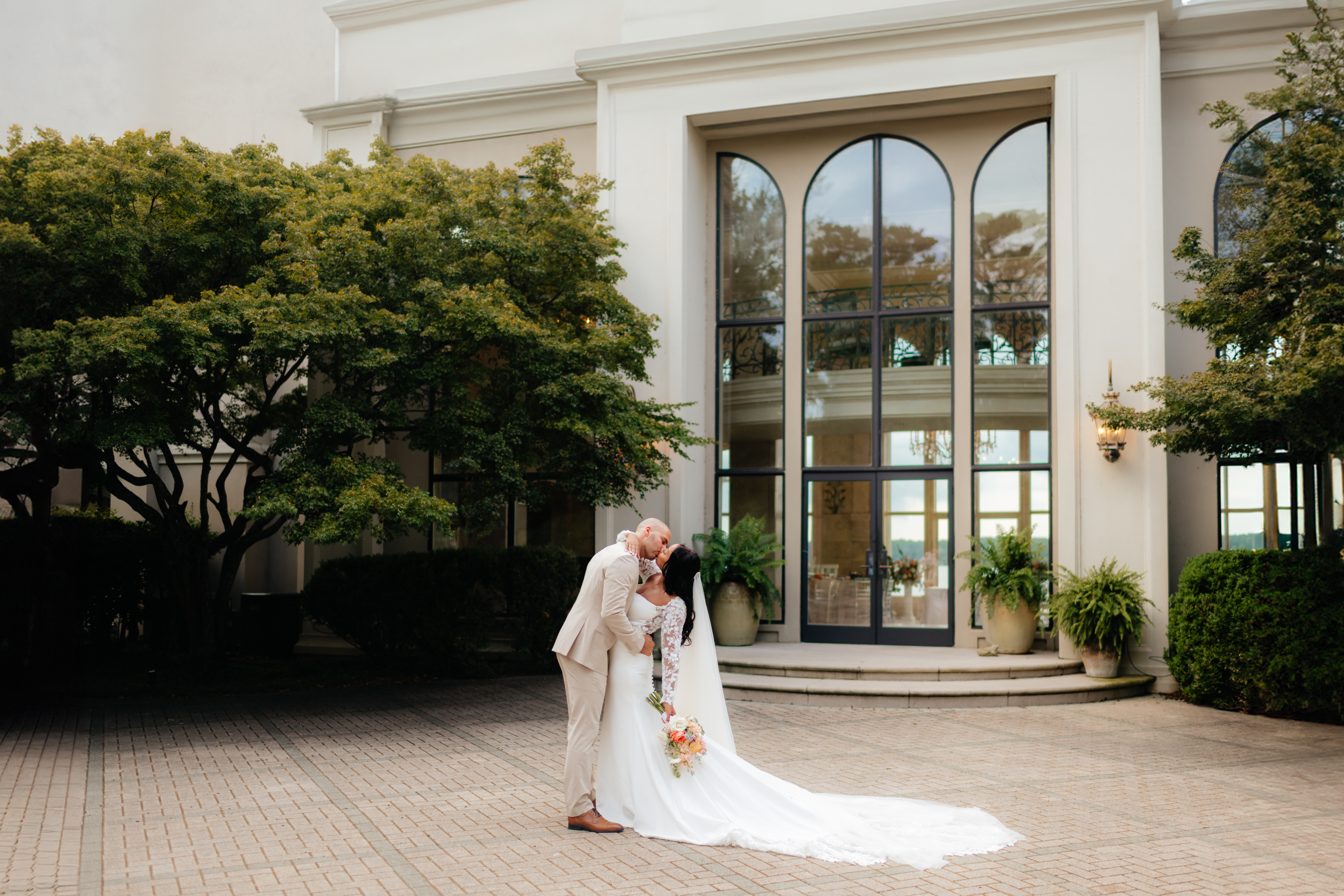 a portrait of a couple kissing after their marriage ceremony taken by alabama wedding photographer Sarah Mismash during a summer wedding at lake Martin near Alexander city