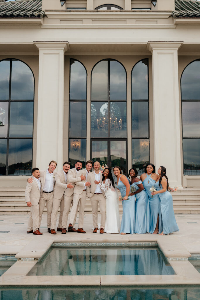 a couple poses with their wedding party after the ceremony at lake Martin, photographed by alabama wedding photographer Sarah Mismash