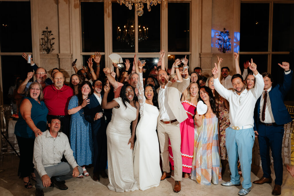 a couple cheers with all their guests and friends on the dance floor during her wedding reception at lake Martin, near Alexander city alabama