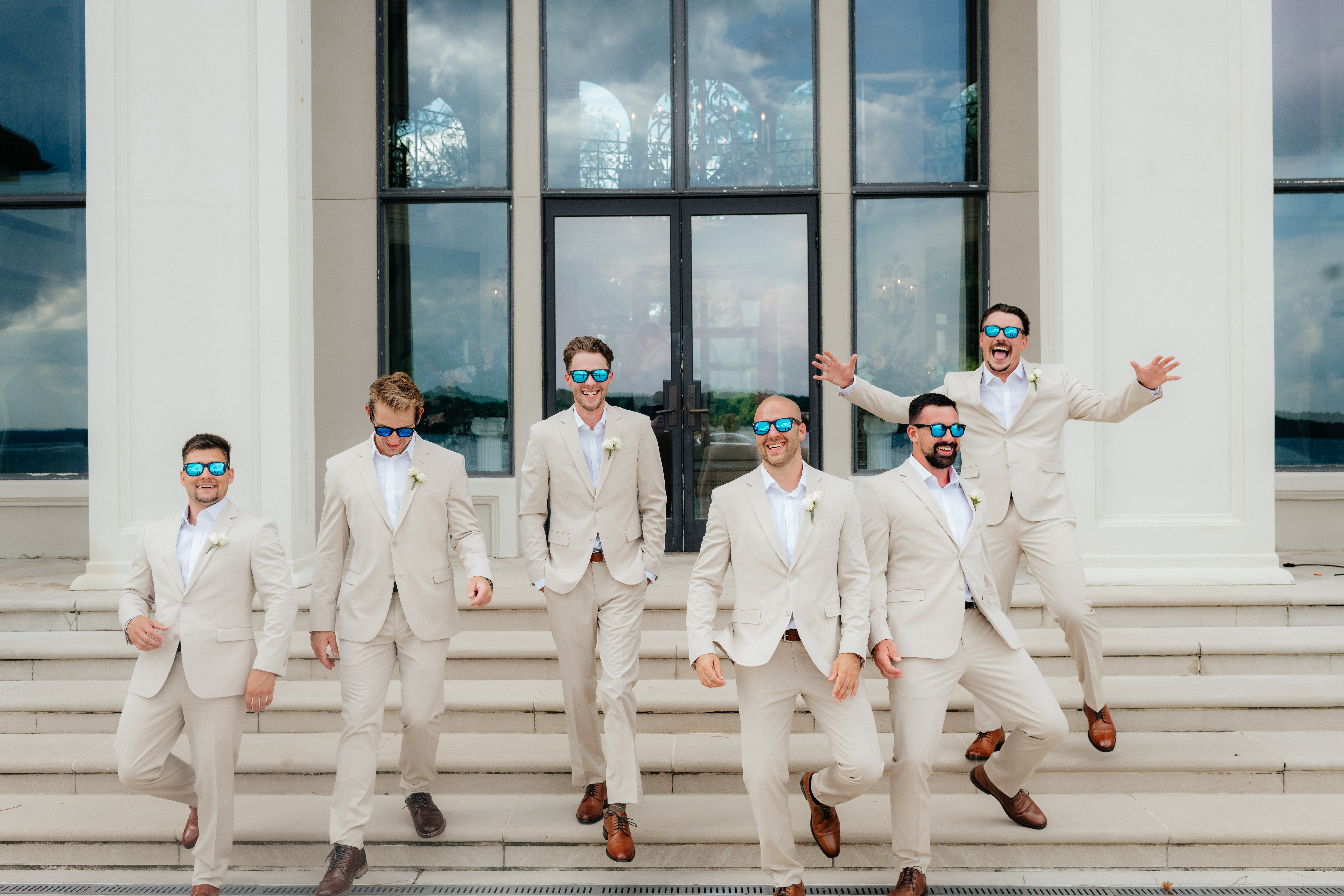 a groom and his groomsmen laugh during photos with alabama wedding photographer Sarah Mismash during a summer wedding at lake Martin near Alexander city