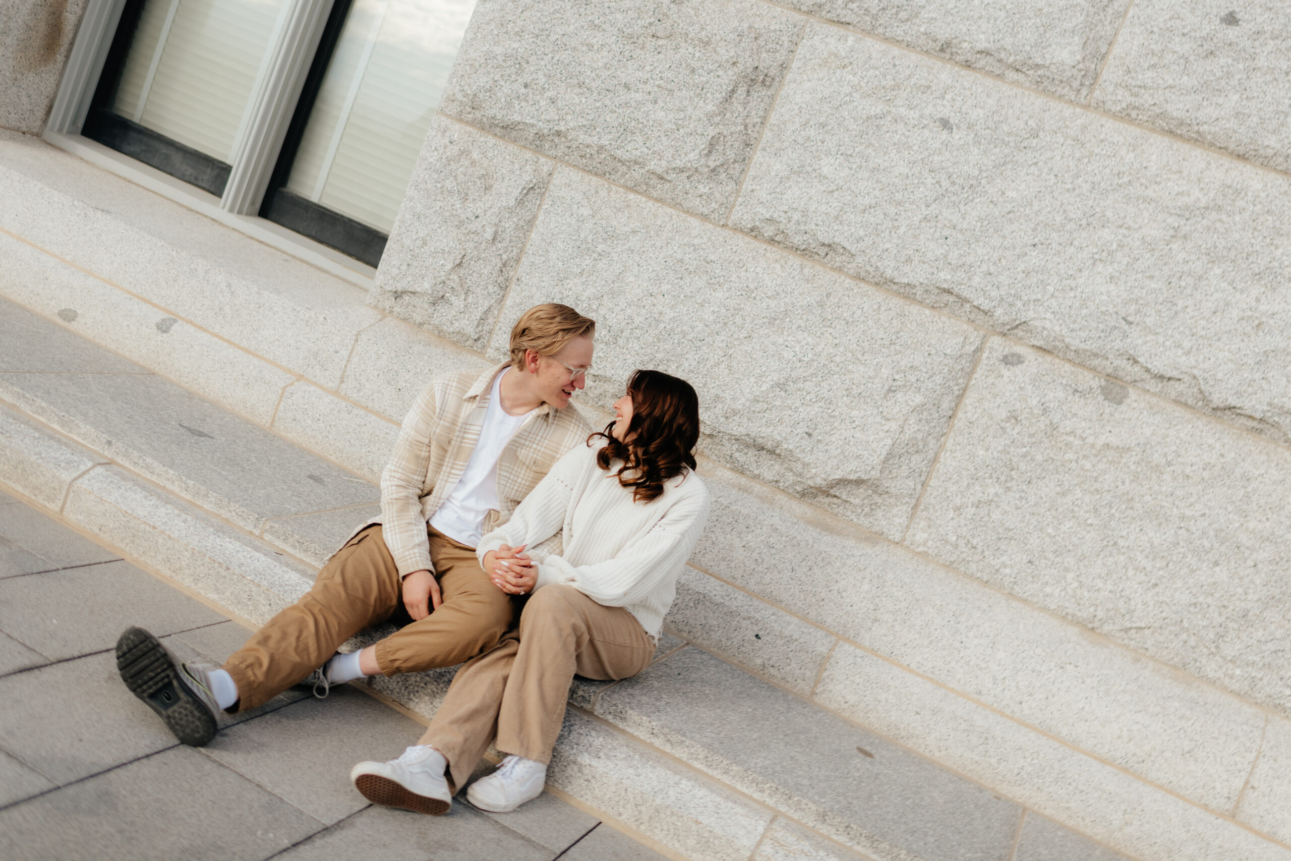 a couple sits together on the steps of the utah state capitol during their engagement photos with seattle washington engagement photographer sarah mismash