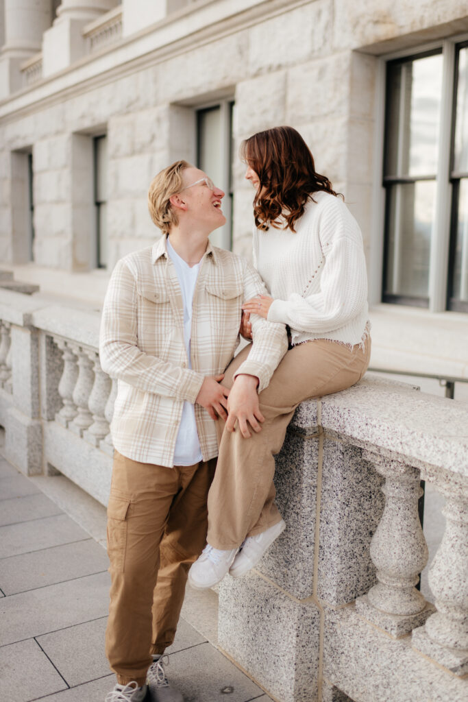 a couple takes snowy enagement photos at the utah state capitol building in salt lake city