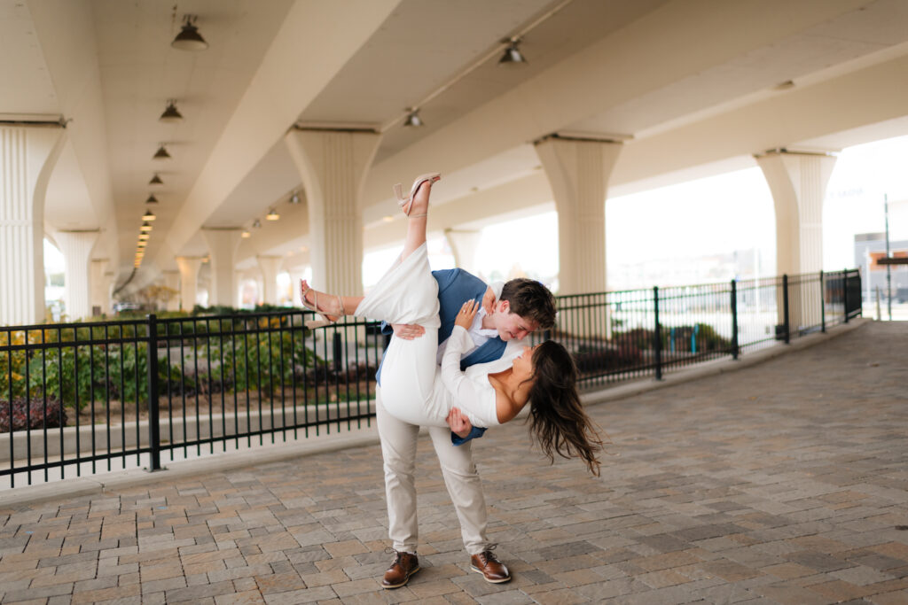 a couple dips for a kiss during their engagement photos at the bham city walk in downtown Birmingham with wedding photographer Sarah Mismash