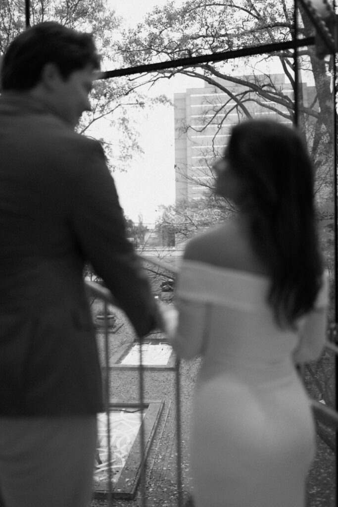a couple pauses on the staircase of the bham museum of art during their urban engagement photos with alabama wedding photographer Sarah Mismash in downtown birmingham