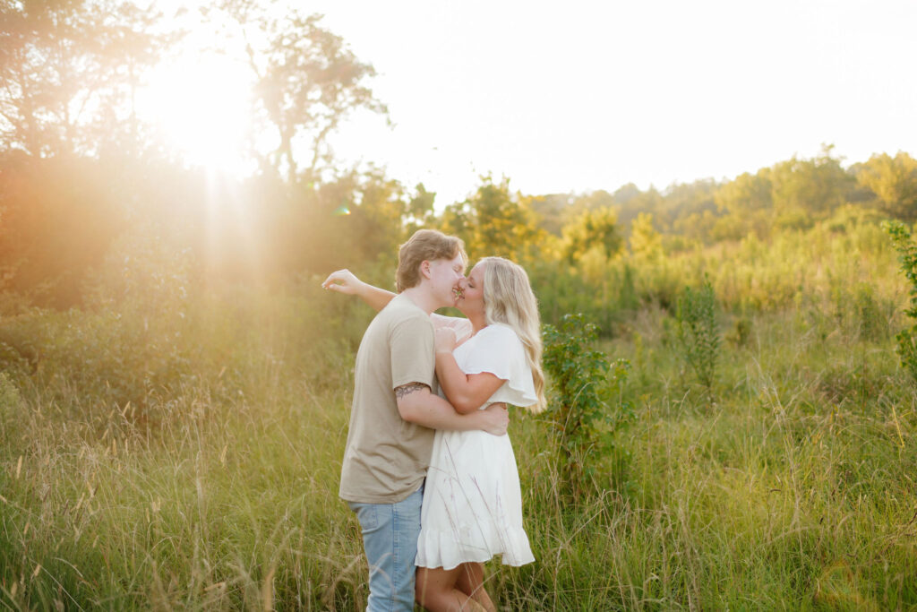 a couple in blue, cream, and tan outfits for their engagement photos kiss during their sessions with washington engagement photographer sarah mismash