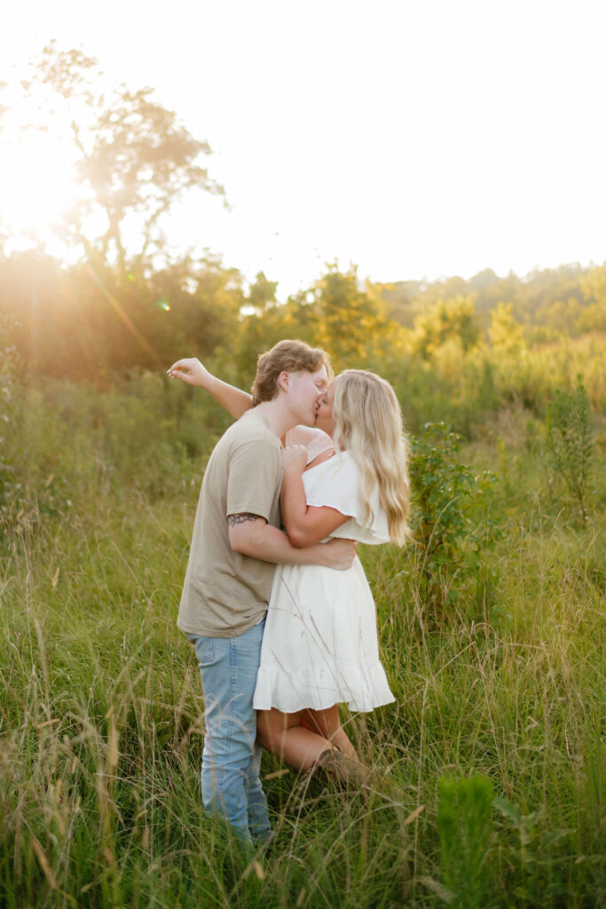 a couple in a white, brown, and blue engagement photo outfit kiss during their engagement session with alabama and seattle engagement photographer sarah mismash