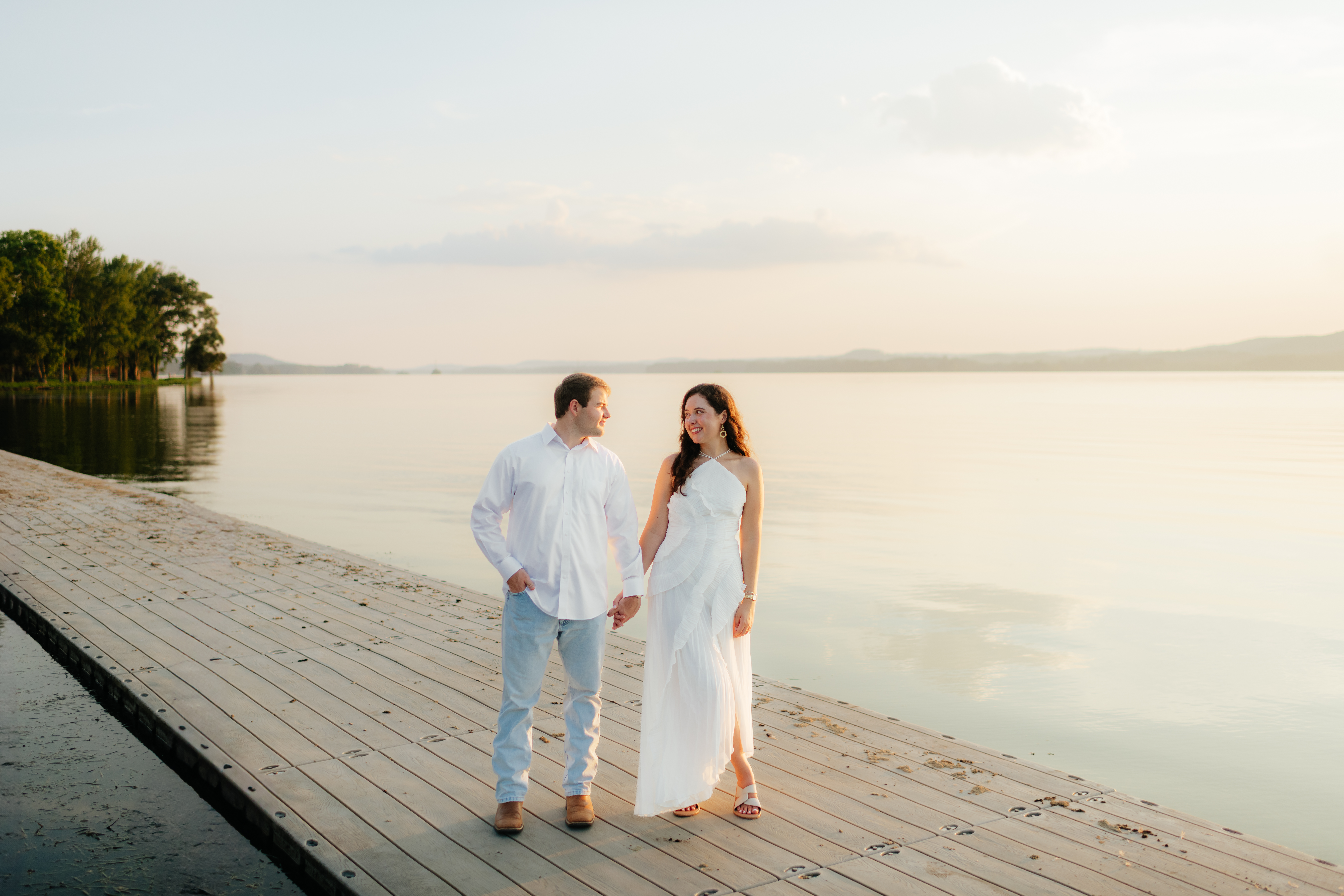 a couple holds hands on a dock at Guntersville Lake during their engagement photography