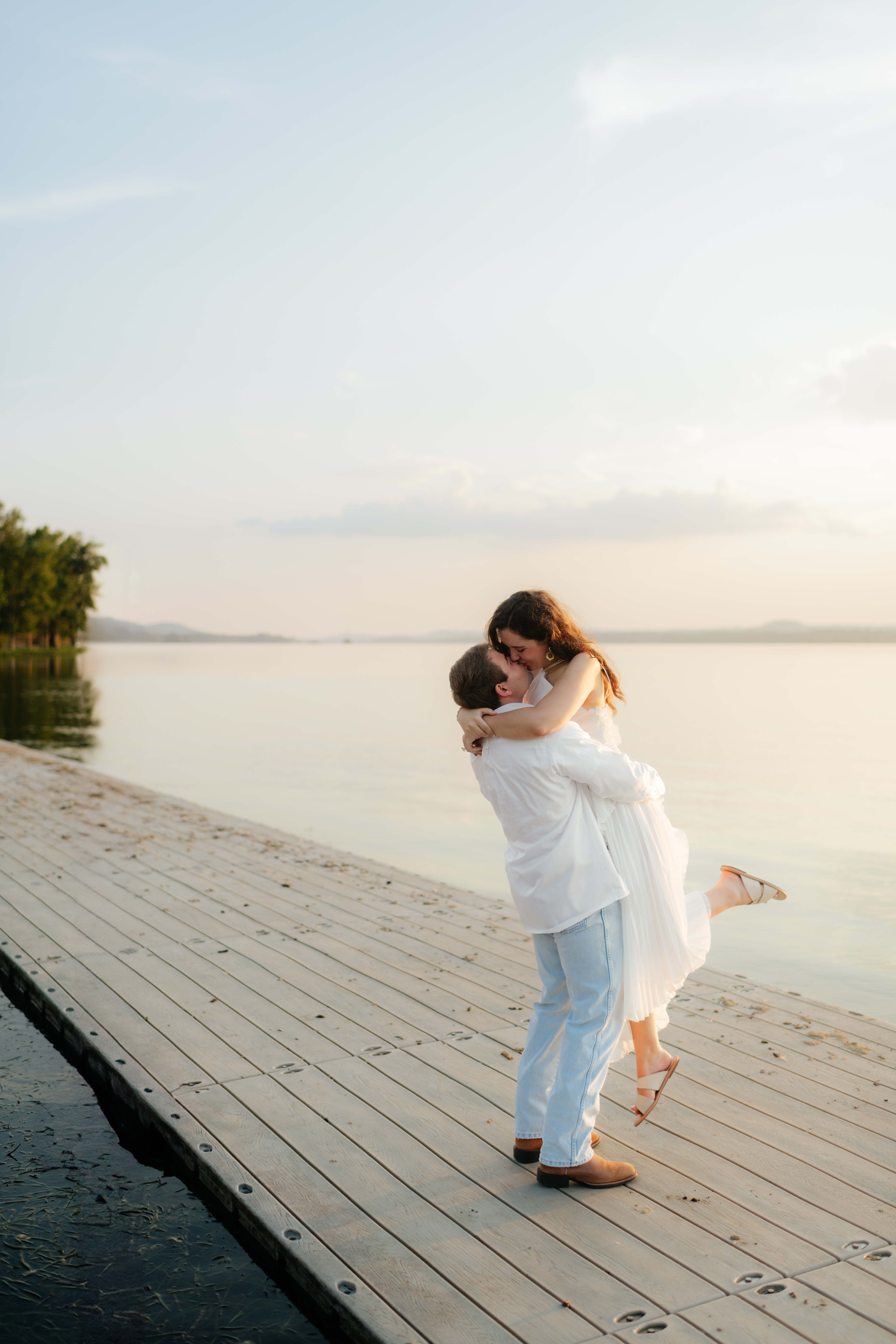 a couple kisses on the dock at Guntersville Lake during their engagement photography with alabama wedding photographer Sarah Mismash
