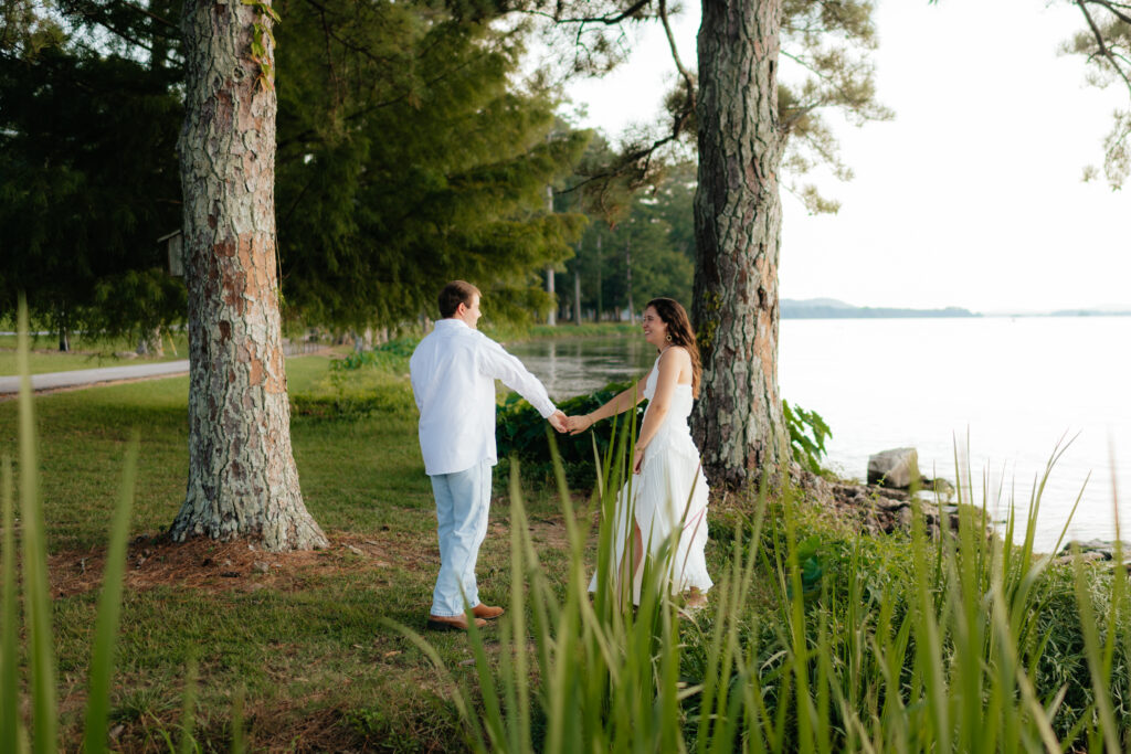 a couple dances near the shore of Guntersville Lake during their engagement photos