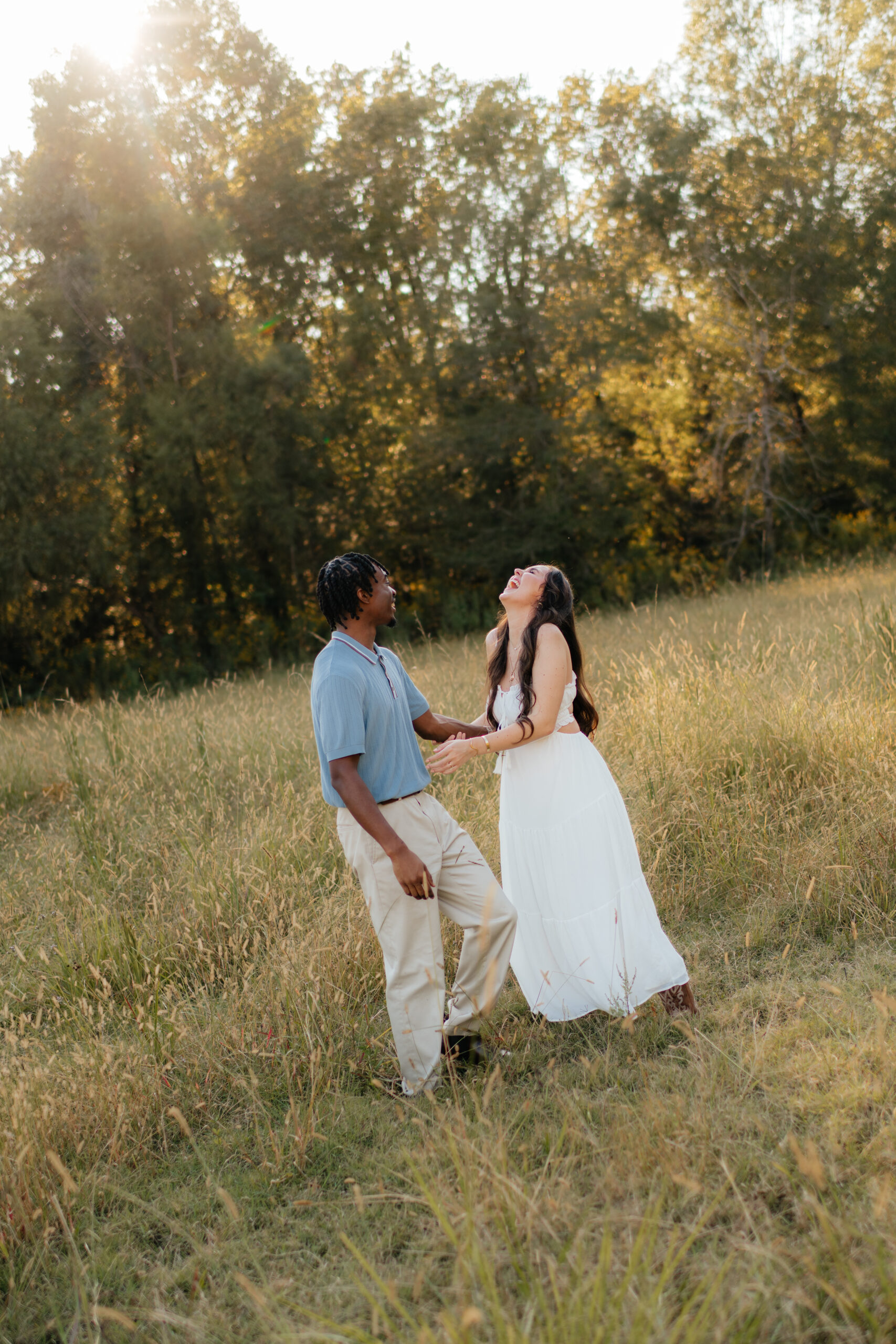 a couple laughs together in a field during their engagement photos with Olympia engagement photographer Sarah Mismash