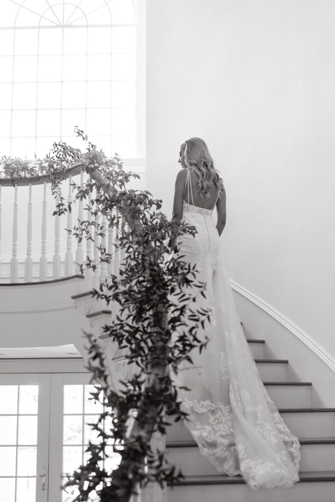 a bride ascends a staircase at her wedding in seattle, washington showing off the train of her beaded wedding dress. photographed by seattle wedding photographer sarah mismash