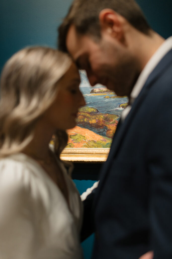 an engaged couple snuggles together together during their engagement photos at the Seattle Art Museum with seattle engagement photographer Sarah Mismash