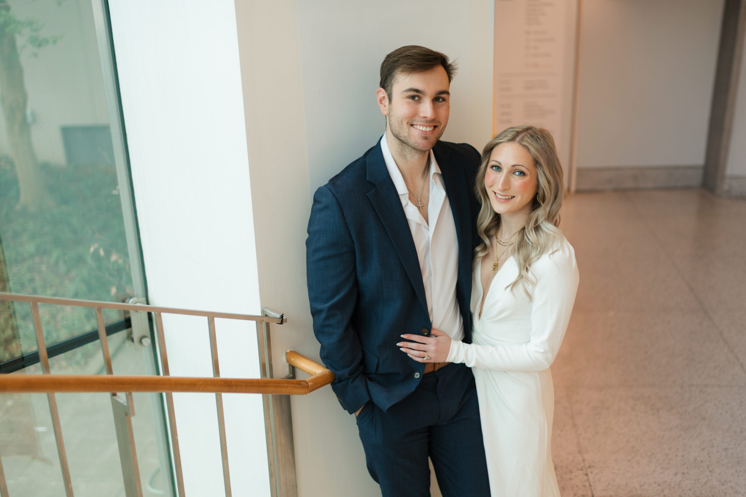 a couple stands at the bottom of the staircase together during their engagement photos at the Seattle Art Museum with seattle engagement photographer Sarah Mismash