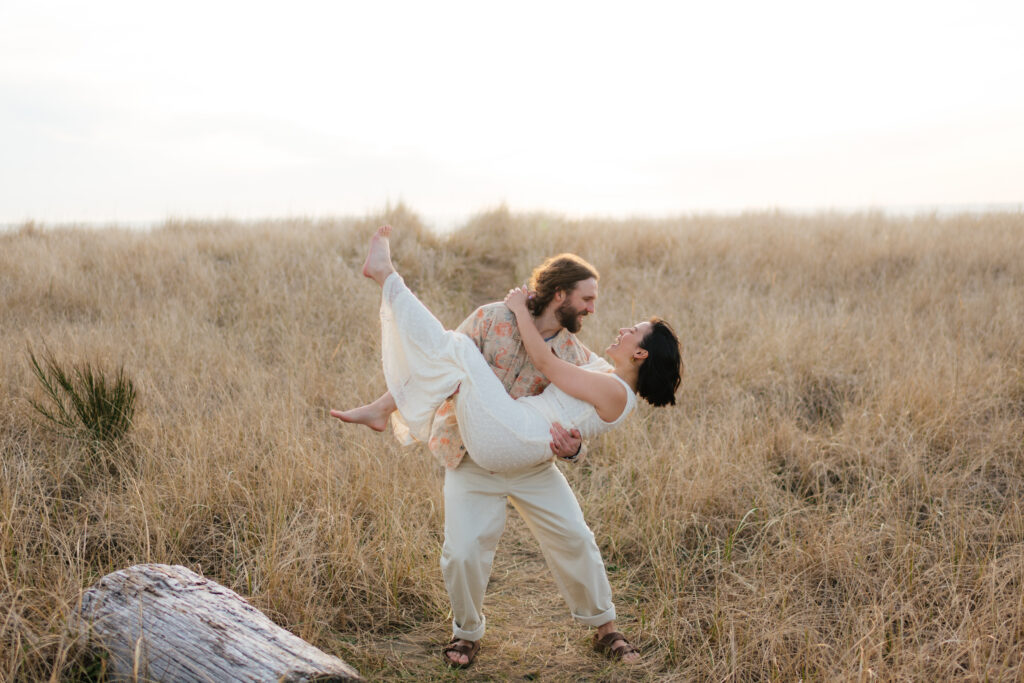 a couple dances together during their dune engagement photos on the washington state coast