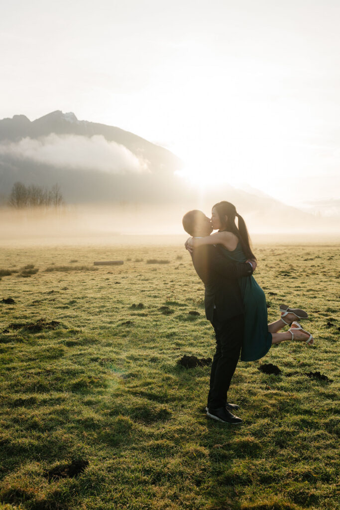 a couple kisses during their engagement photos at the north bend elk fields near mt si in Snoqualmie, washington