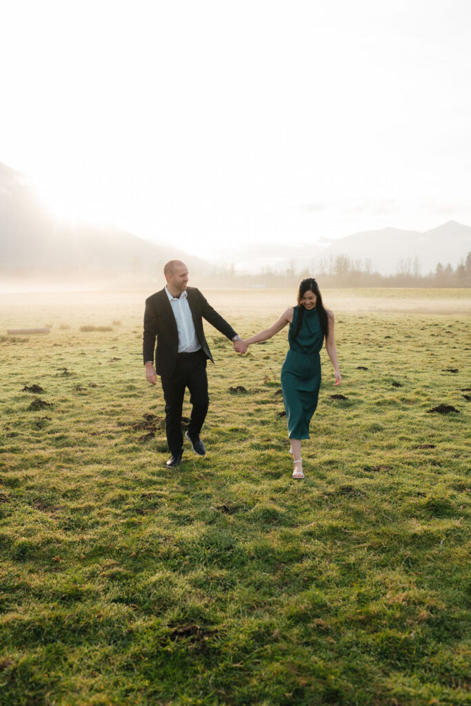 a couple holds hands during their engagement photos at the north bend elk fields near Mount Si in Snoqualmie, washington