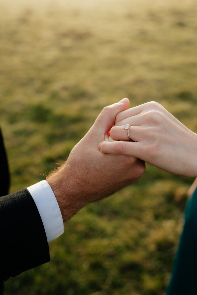 a couple holds hands during their engagement photos at the north bend elk fields near Mount Si in Snoqualmie, washington