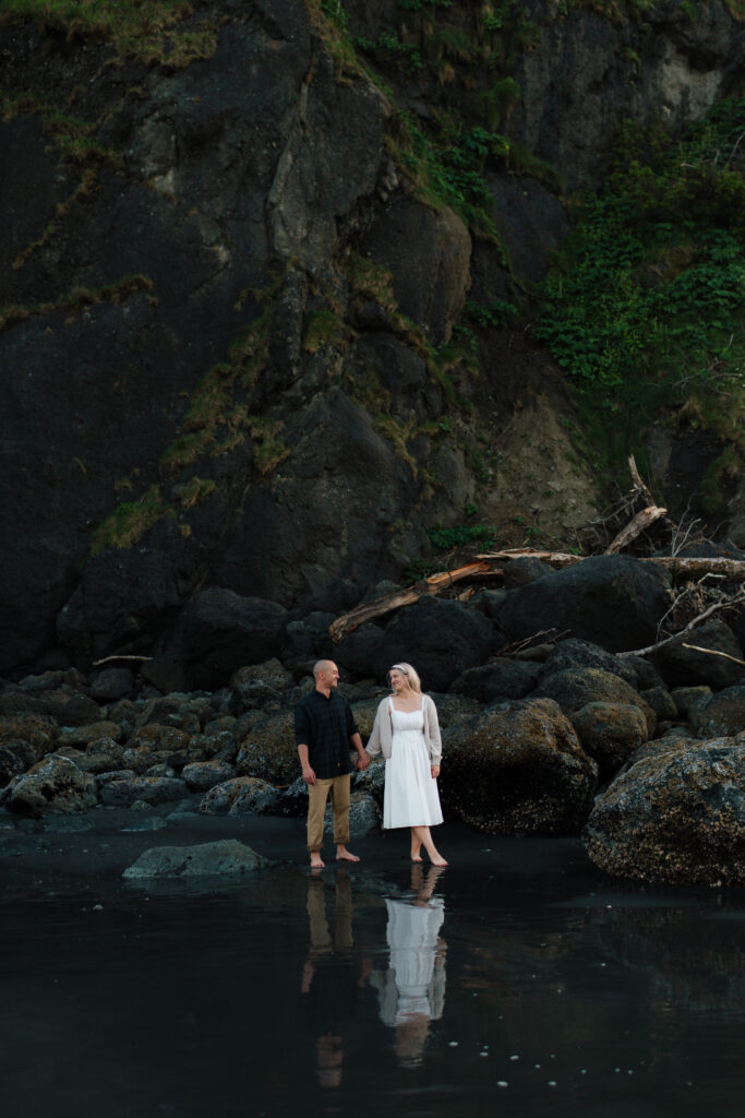 a couple holds hands during their ruby beach engagement photos in the pnw