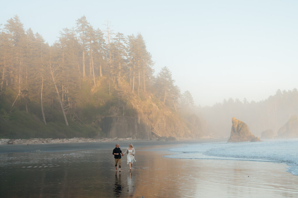 a couple runs across ruby beach during golden hour during their summer engagement photos in forks, washington
