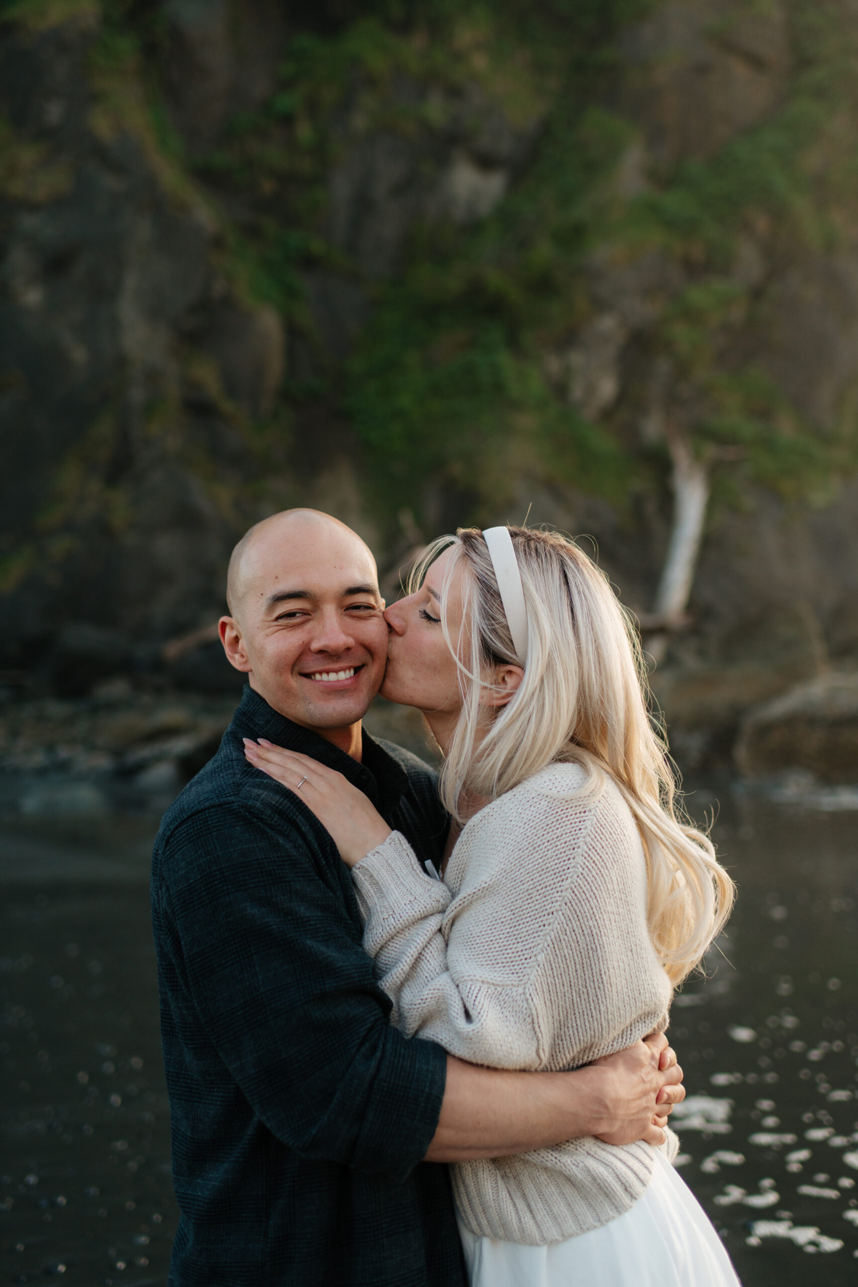 a couple kisses during their summer engagement photos on the washington coast
