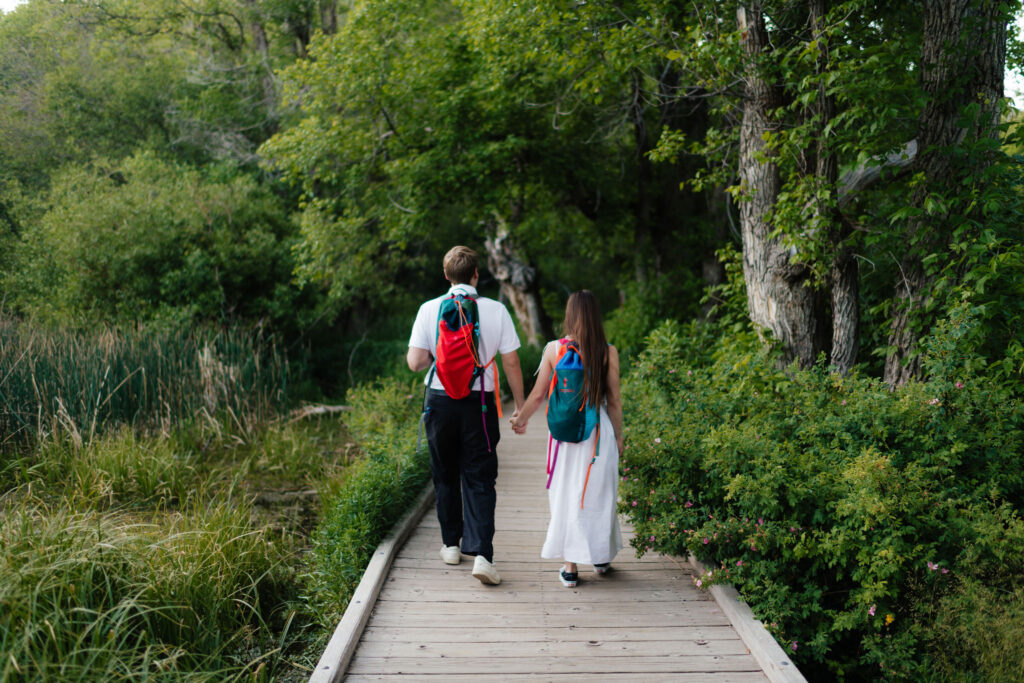 a couple walks away from utah engagement photographer sarah mismash during their engagement photos on the alpine loop