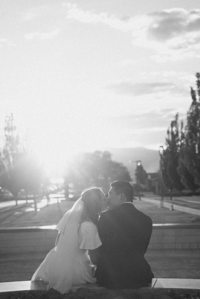 a couple kisses at sunset during their bridal portraits at the orem temple