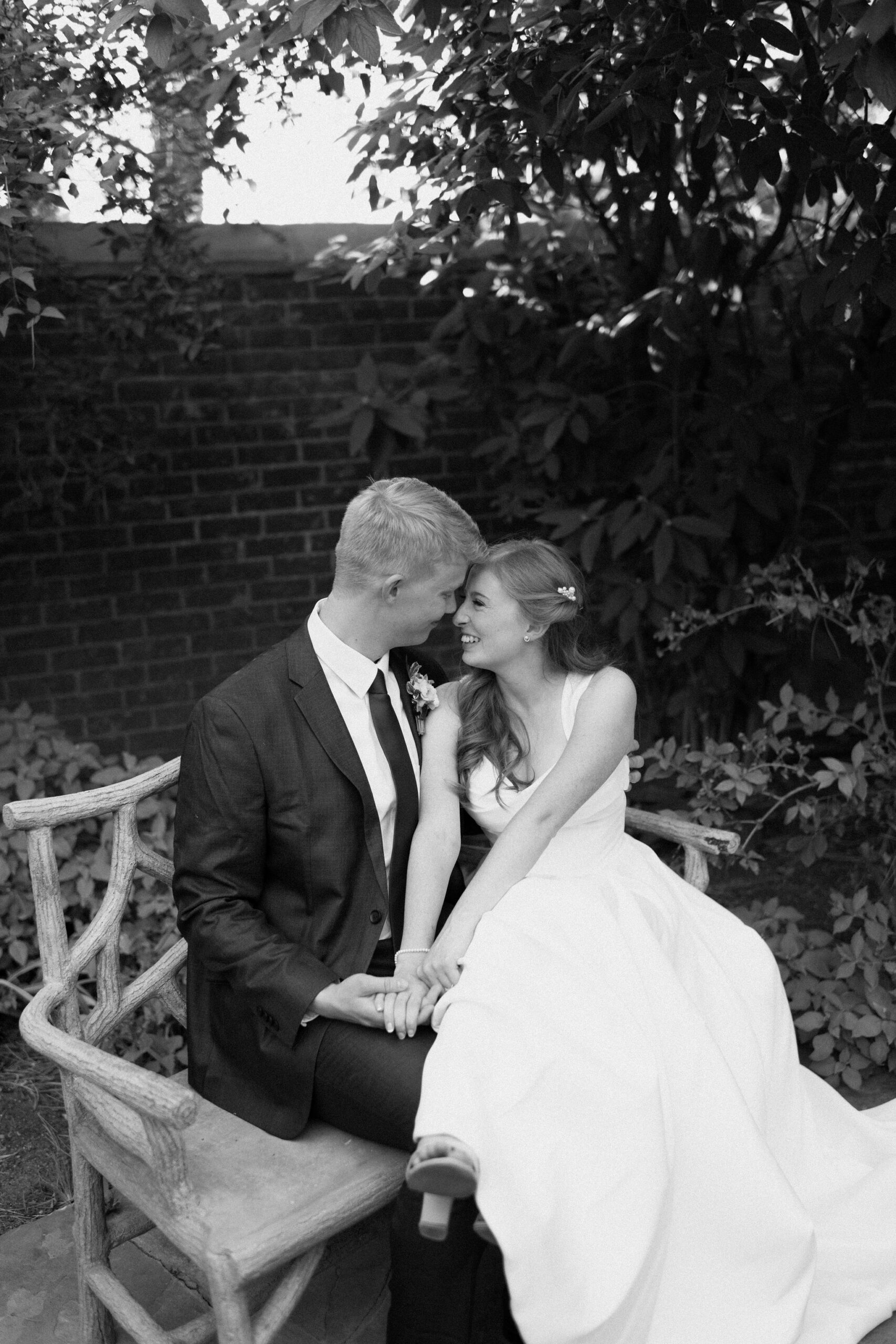 a couple laughs together in the secret garden section of ashton gardens at thanksgiving point, in lehi during their bridal portraits with utah wedding photographer sarah mismash