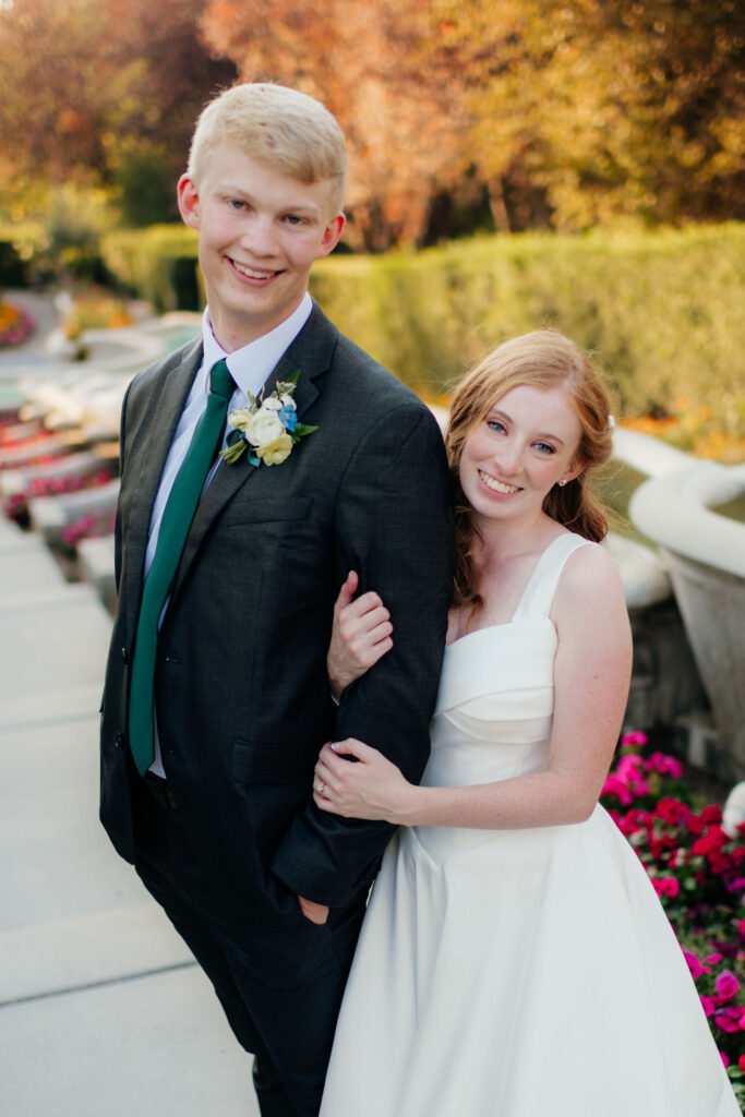a couple smiles for utah wedding photographer sarah mismash during their august bridal wedding portraits at ashton gardens, thanksgiving point, in lehi