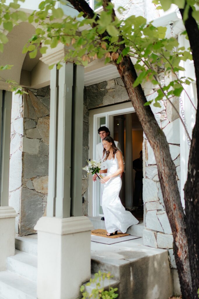 a couple heads out the door with her bouquet as the morning of her September wedding at the Provo City Center Temple gets underway.